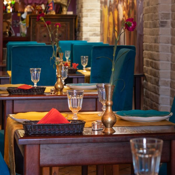 wnętrze indyjskiej restauracji w Rzeszowie, stoły drewniane z niebieskimi krzesłami